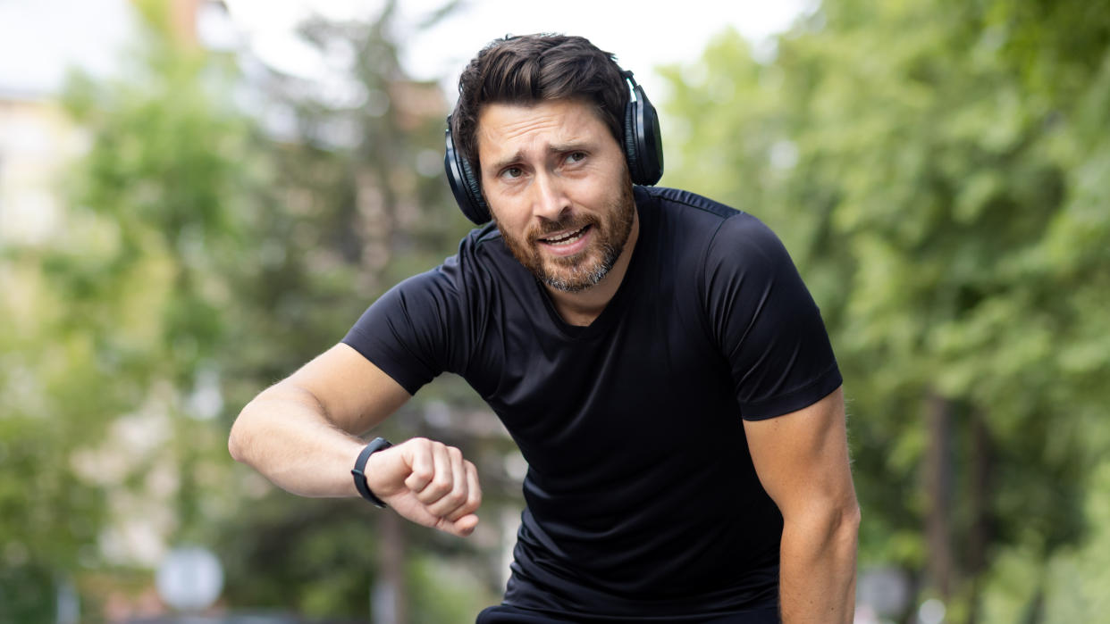  Tired man checking sports watch after a run. 