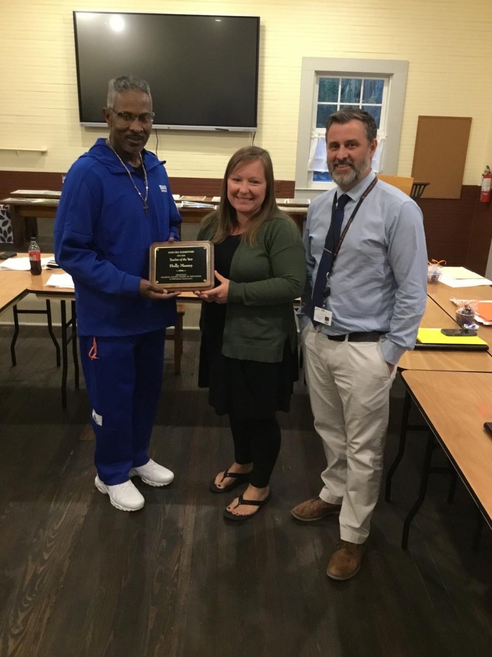 Madison County Board of Education member Kevin Barnette, left, and Mars Hill Elementary School Principal Jimmy McGregor present Holly Massey a plaque honoring her as Mars Hill Elementary's 2023 Teacher of the Year.