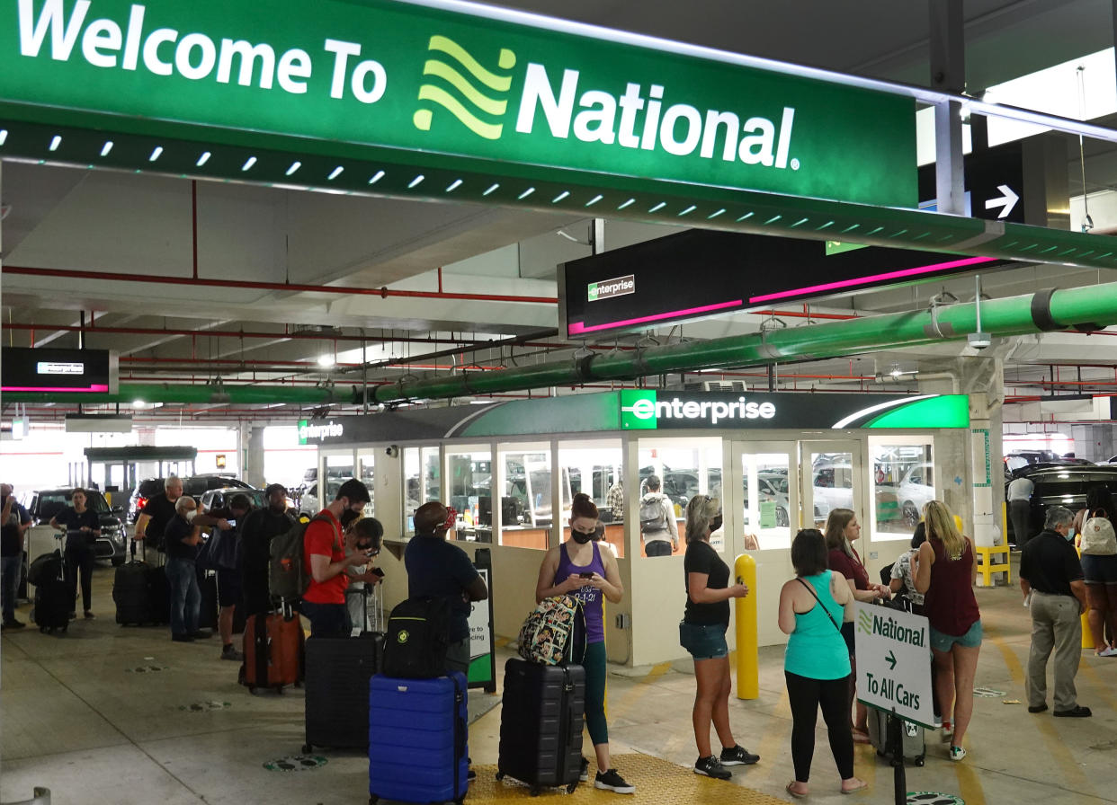 People wait in line at Enterprise rental agency in the Miami International Airport Car Rental Center on April 12, 2021, in Miami, Florida. Customers are finding that car rental agencies have limited or no supply of vehicles as people begin traveling again after being locked down during the pandemic. (Photo by Joe Raedle/Getty Images)