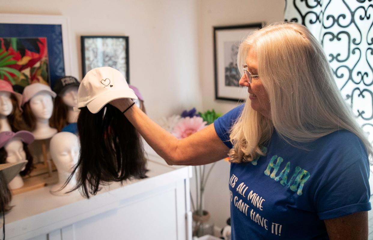 Denise DiFelice shows an example of a hat she and her sister made at her Cape Coral home. Denise's sister Diane Hamilton came up with the idea when Denise began losing her hair from chemotherapy.