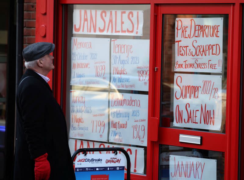 A man looks at offers in the window of a travel agents shop in the town centre, amid the coronavirus disease (COVID-19) outbreak in Wigan