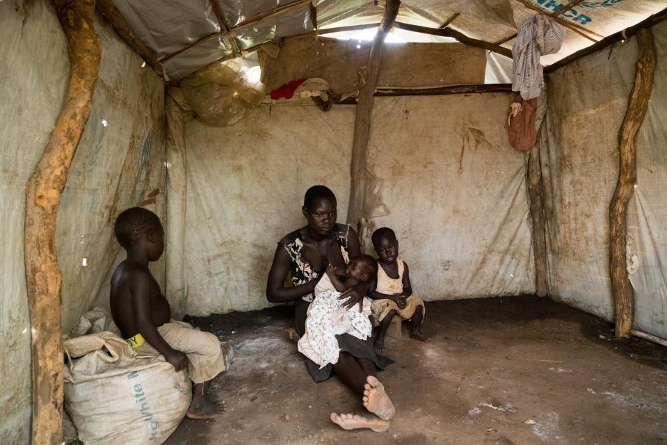 Filda Ayet, age 23, with her three children, Bosco, 5, Winnie, 3, and 3-month-old Peter in their home in a settlement for refugees that have fled from South Sudan to Uganda, June 25, 2019