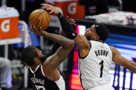 Los Angeles Clippers guard Paul George, left, shoots as Brooklyn Nets guard Bruce Brown defends during the second half of an NBA basketball game Sunday, Feb. 21, 2021, in Los Angeles. (AP Photo/Mark J. Terrill)