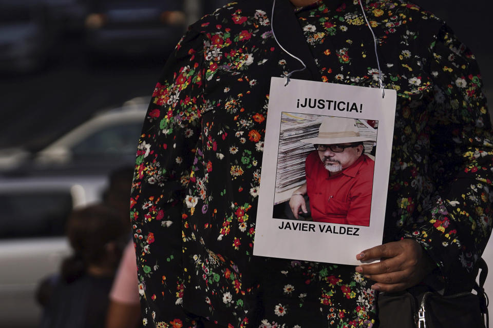 Griselda Triana sostiene una foto de su esposo Javier Valdez, quien fue asesinado en Culiacán el 15 de mayo de 2017, durante una protesta por la ola de asesinatos de periodistas, el lunes 9 de mayo de 2022, en el monumento Ángel de la Independencia de la Ciudad de México. (AP Foto/Marco Ugarte)