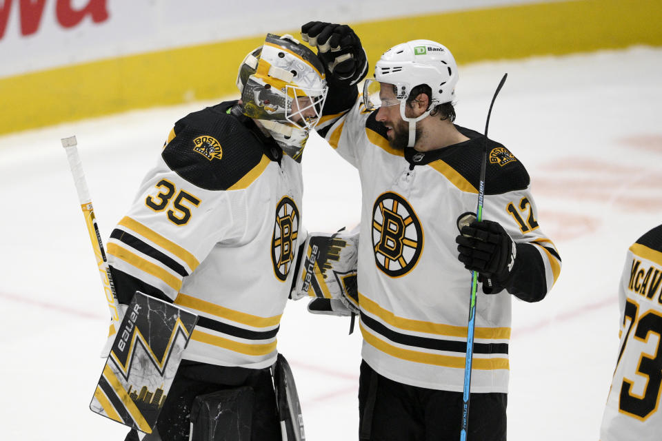 Boston Bruins goaltender Linus Ullmark (35) and center Craig Smith (12) celebrate after an NHL hockey game against the Washington Capitals, Monday, Jan. 10, 2022, in Washington. (AP Photo/Nick Wass)