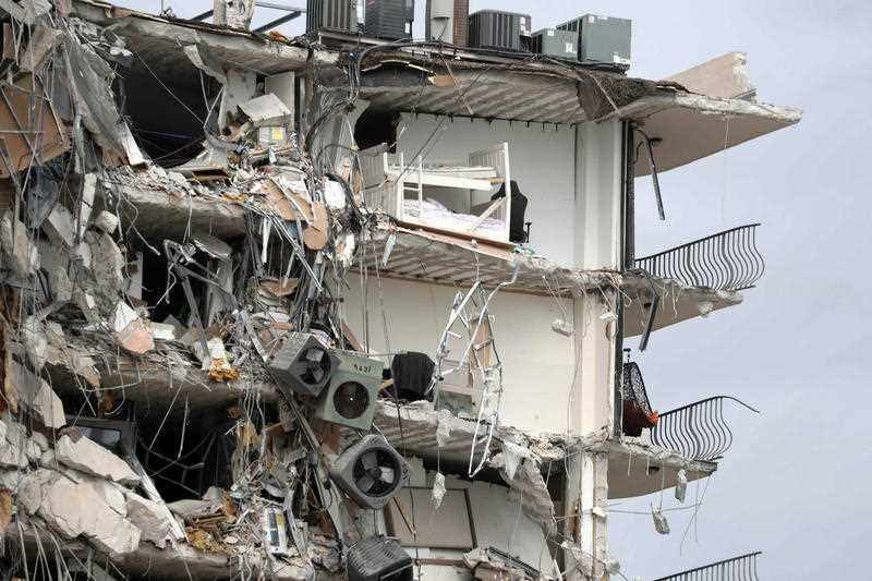 Items and debris dangle from a section of the oceanfront Champlain Towers South Condo that partially collapsed on Thursday.