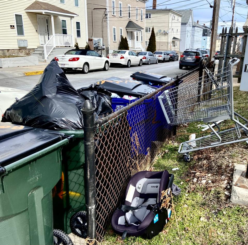 Overstuffed trash and recycle bins stand outside an apartment house on John Street in Fall River in this 2022 file photo.