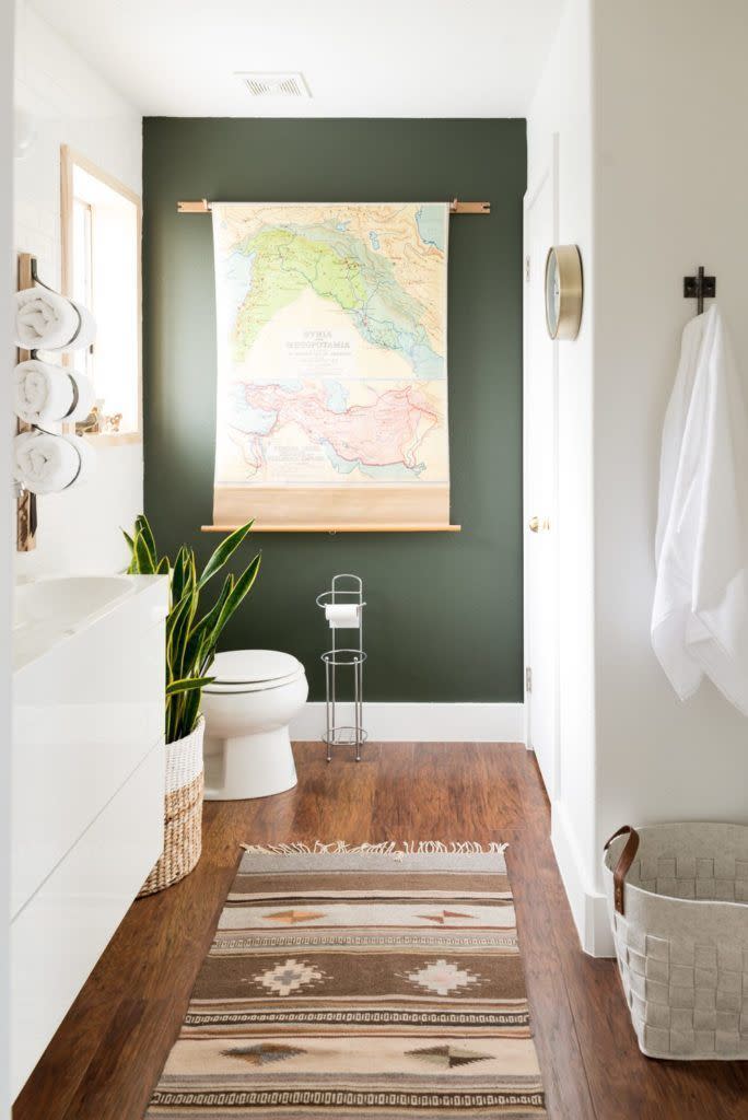 <p>Give a basic bathroom a bohemian-inspired upgrade with an emerald green accent wall. Add an oversized piece of art, like this map, to make even more of an impact. </p>