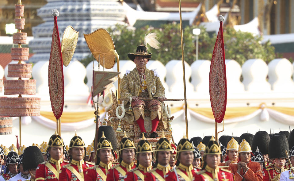 WIth Queen Suthida, bottom right, in official Royal Guard uniform, Thailand's King Maha Vajiralongkorn is transported on the royal palanquin during the Royal Procession through city streets during the three-day coronation ceremony, Sunday, May 5, 2019, in Bangkok, Thailand. (AP Photo/Rapeephat Sitchailapa)