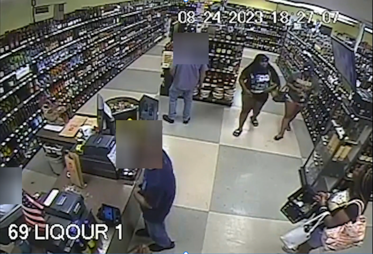 Ta'Kiya Young, standing in line, lower right, is joined by two other women in the liquor store of a Kroger in Blendon Township on August 24 before all three leave the store together.