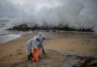 Sri Lankan navy soldiers clean the plastic debris washed ashore from fire damaged container ship MV X-Press Pearl at Kapungoda, on the outskirts of Colombo, Sri Lanka. Monday, June 14, 2021. (AP Photo/Eranga Jayawardena)