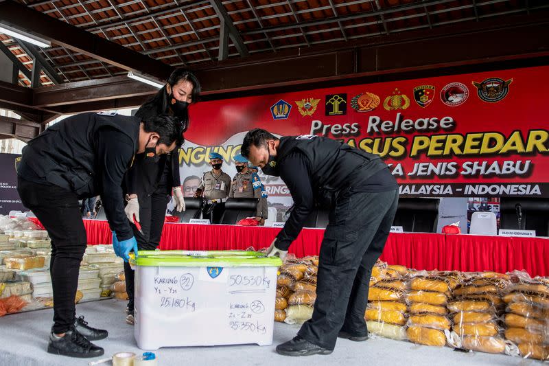 Indonesian police arrange drug evidence during media conference in Jakarta