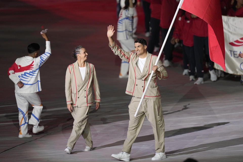 Kristel Köbrich and Esteban Grimalt of Chile carry their country's flag during the opening ceremony of the Pan American Games at the National Stadium in Santiago, Chile, Friday, Oct. 20, 2023. (AP Photo/Silvia Izquierdo)
