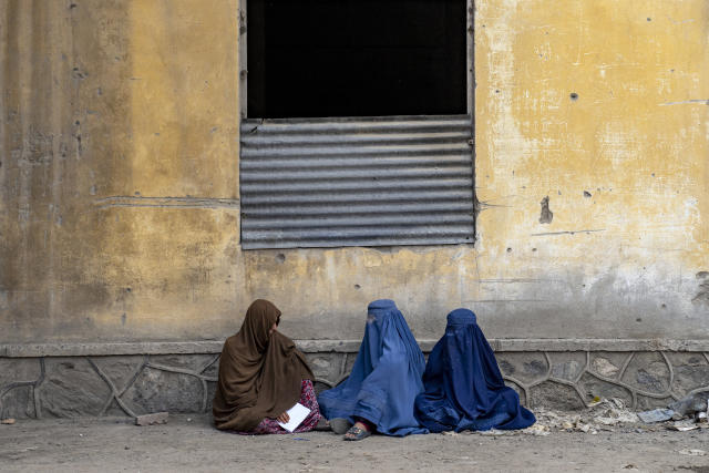 Afghan women wait to receive food rations distributed by a humanitarian aid group, in Kabul, Afghanistan, Tuesday, May 23, 2023. (AP Photo/Ebrahim Noroozi)