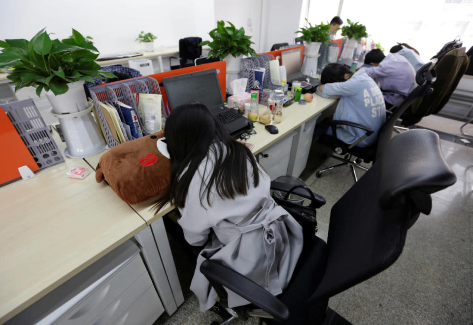 Employees at Goopal Group in Beijing take a nap in their seats after lunch on April 21, 2016. (Jason Lee/Reuters)