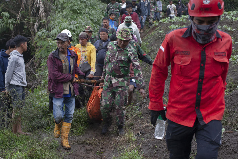 Rescuers carry the body of a victim of the eruption of Mount Marapi in Batu Palano, West Sumatra, Indonesia, Tuesday, Dec. 5, 2023. Rescuers searching the hazardous slopes of the volcano found more bodies of climbers who were caught by a surprise weekend eruption, raising the number of confirmed dead to nearly two dozens, officials said Tuesday. (AP Photo/Sigit Putra)