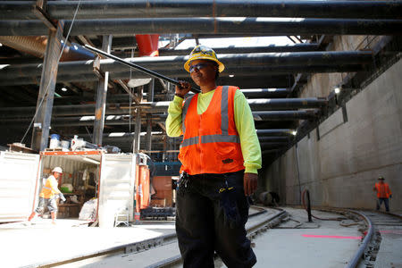 Construction site worker Joundi White, 31, walks down a railway track at the construction site where she works in Los Angeles, California, United States, June 16, 2016. REUTERS/Lucy Nicholson