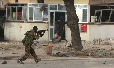 A Somali government soldier runs to take position during gunfire after a suicide bomb attack outside Nasahablood hotel in Somalia's capital Mogadishu, June 25, 2016. REUTERS/Feisal Omar