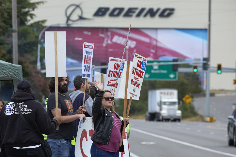 Boeing Machinists Union member Stephanie Corona waves to passing traffic while on the picket line at the Everett plant, Friday, Sept. 13, 2024, in Everett, Wash. (AP Photo/John Froschauer)