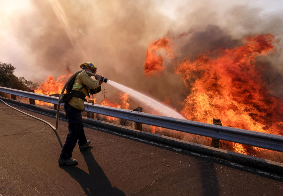 A firefighter battles a fire along the Ronald Reagan Freeway, aka state Highway 118, in Simi Valley, California, Nov. 12, 2018.&nbsp; (Photo: ASSOCIATED PRESS)