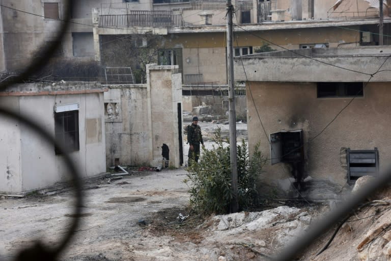 A member of the Syrian pro-government forces patrols in west Aleppo's Ithaa district on December 11, 2016