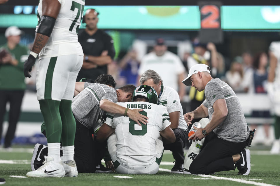 EAST RUTHERFORD, NEW JERSEY - SEPTEMBER 11: Aaron Rodgers #8 of the New York Jets is looked at by the medical staff on the field for an apparent injury during a game against the Buffalo Bills at MetLife Stadium on September 11, 2023 in East Rutherford, New Jersey. (Photo by Michael Owens/Getty Images)