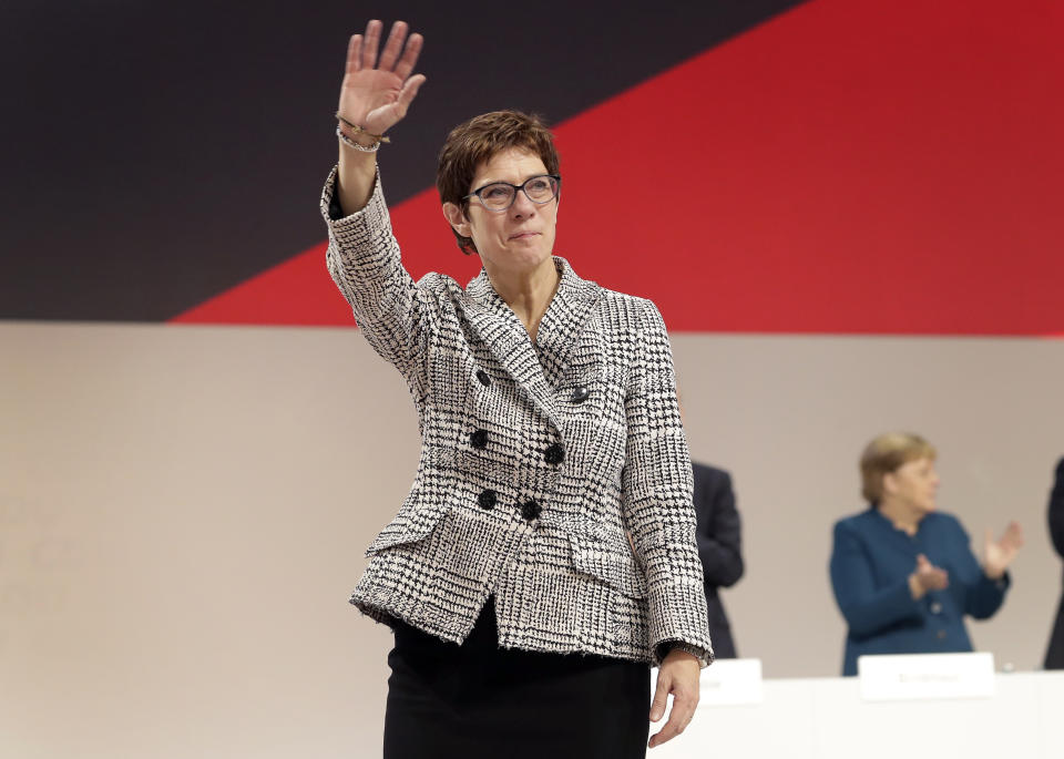 Newly elected CDU chairwoman Annegret Kramp-Karrenbauer, left, waves during the party convention of the Christian Democratic Party CDU in Hamburg, Germany, Friday, Dec. 7, 2018, after German Chancellor Angela Merkel didn't run again for party chairmanship after more than 18 years at the helm of the party. (AP Photo/Michael Sohn)