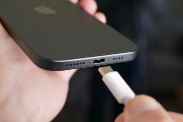 A person plugging in the USB C charger to the Apple iPhone 15 Plus.