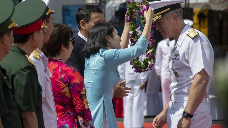 In this photo provided by U.S. Navy, Rear Adm. Pat Hannifin, right, receives a wreath during a welcome ceremony after the aircraft carrier Ronald Reagan, anchored into Da Nang, Vietnam, for a routine port visit, Sunday, June 25, 2023.  (MCS2 Keyly Santizo/U.S. Navy via AP)