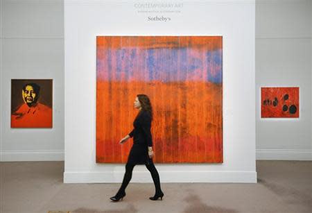An employee poses with artist Gerhard Richter's artwork "Wand (Wall)" in between works by Andy Warhol "Mao" (L) and Alberto Rossi's "Rosso Plastica" (R) at Sotheby's auction house in London January 29, 2014. REUTERS/Luke MacGregor