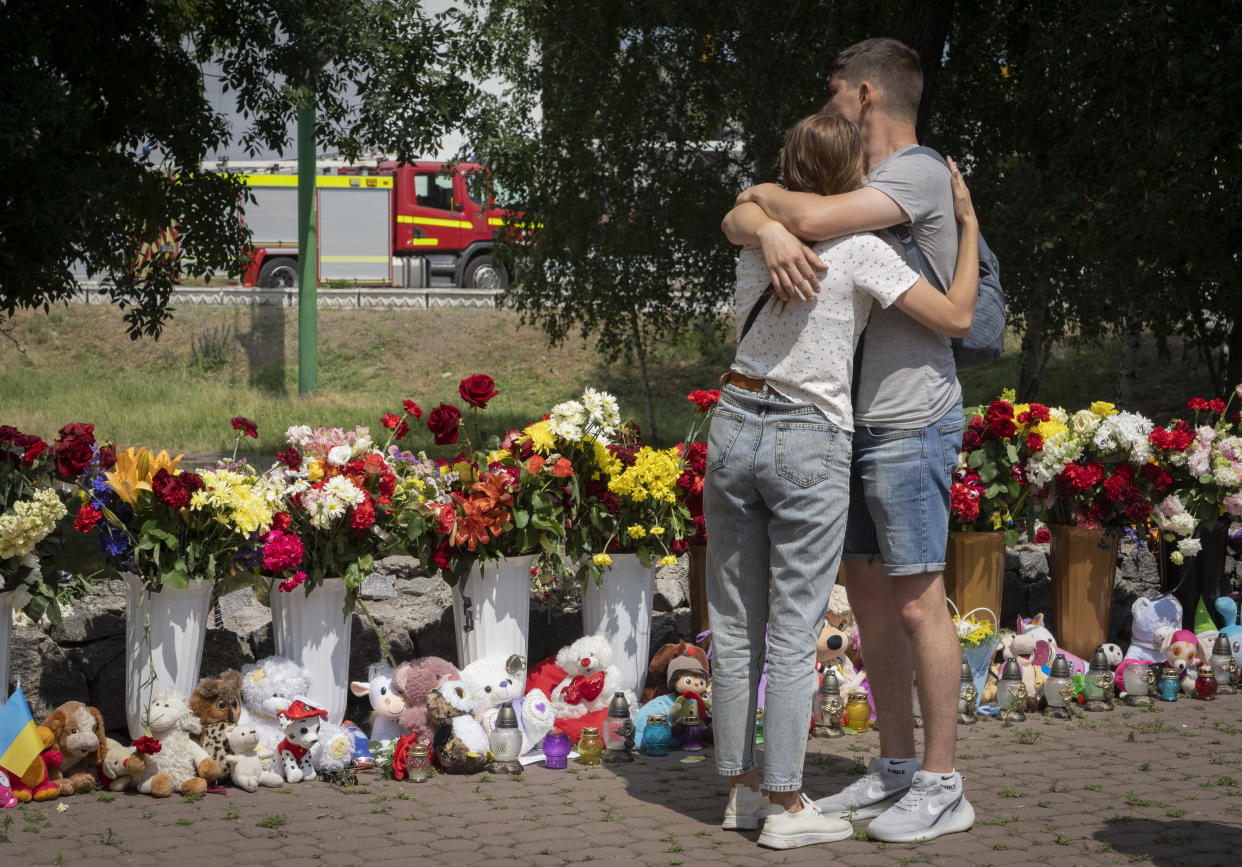 People lay flowers to pay the last respect to victims of the Russian rocket attack at a shopping center in Kremenchuk, Ukraine, Wednesday, June 29, 2022. (AP Photo/Efrem Lukatsky)