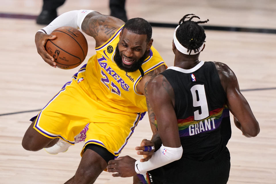 Los Angeles Lakers' LeBron James (23) drives against Denver Nuggets' Jerami Grant (9) during the first half of an NBA conference final playoff basketball game Thursday, Sept. 24, 2020, in Lake Buena Vista, Fla. (AP Photo/Mark J. Terrill)