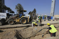 A road crew works on a road outside the Formula One corniche circuit, in Jiddah, Saudi Arabia, Sunday, Nov. 21, 2021. Next month's F1 race will be the first time Saudi Arabia hosts the premier sporting event, though the kingdom has hosted the lesser known Formula-E race in past years in an effort to raise the country's profile as a tourist destination. (AP Photo/Amr Nabil)