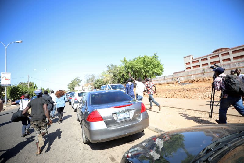 Members of the media run after opponents of Nigerian activist Omoyele Sowore attacked a freedom rally in Abuja