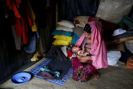 Minara Begum, 22, holds her one-month-old son Ayub as she sits inside their shelter in Kutupalang unregistered refugee camp in Cox’s Bazar, Bangladesh, February 10, 2017. REUTERS/Mohammad Ponir Hossain