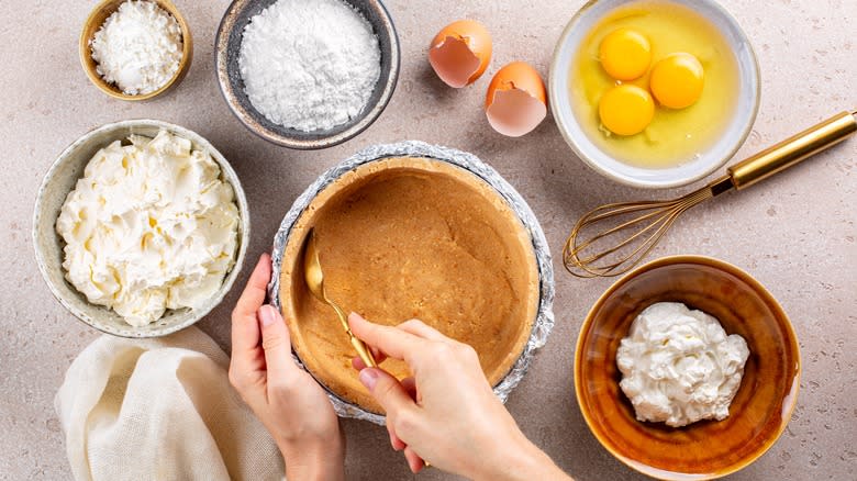 Person shaping pie crust tin