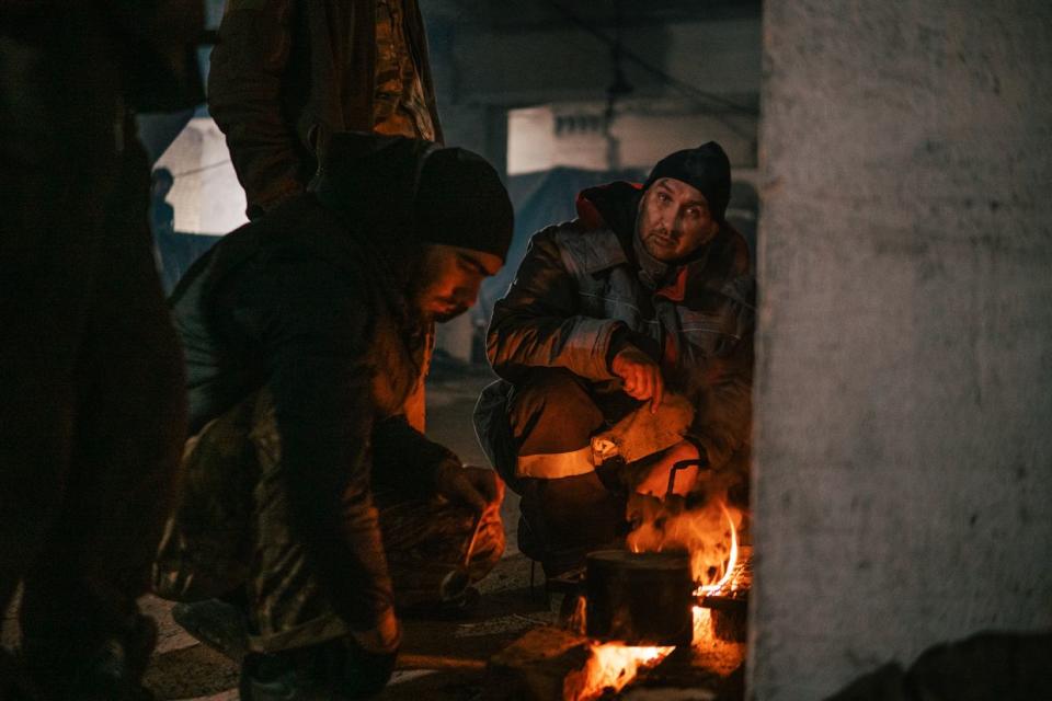 Ukrainian soldiers cook near the fire in the bunker of the Azovstal steel plant in Mariupol, Ukraine on May 7, 2022. (Personal archive / Dmytro Kozatskyi)