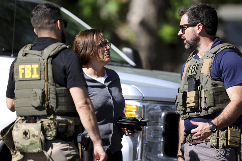 Members of FBI talk with each other at the scene of a shooting on Galway Drive in Charlotte, N.C., on Monday, April 29, 2024, Multiple law enforcement officers were shot while serving a warrant for a felon wanted for possessing a firearm. (Khadejeh Nikouyeh/The Charlotte Observer via AP)