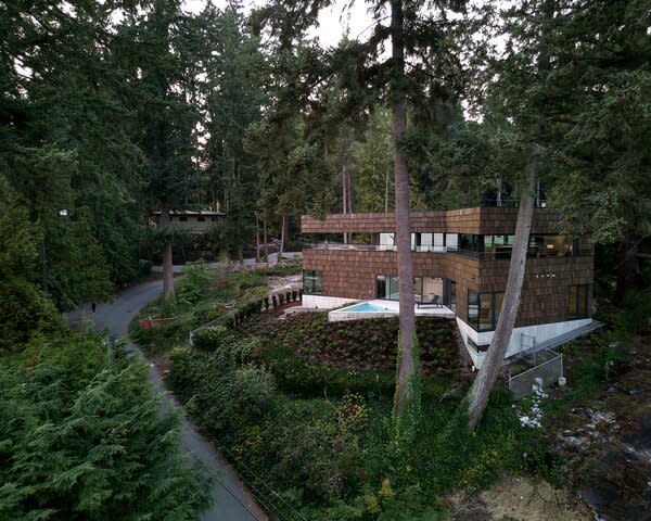 The three-story, cedar-clad home sits on an elevated lot overlooking the Burrard Inlet, a shallow-sided fjord separating the coastal mountain range from the city of Vancouver.