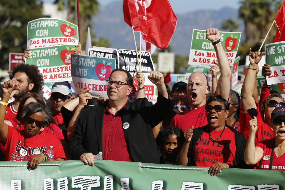 In this Saturday, Dec. 15, 2018 photo, United Teachers Los Angeles President Alex Caputo-Pearl, center, joins teachers at a rally next to the Broad Museum in Los Angeles. Teachers in the nation's second-largest school district will go on strike next month if there's no settlement of its long-running contract dispute, union leaders said Wednesday, Dec. 19. The announcement by United Teachers Los Angeles threatens the first strike against the Los Angeles Unified School District in nearly 30 years and follows about 20 months of negotiations. (AP Photo/Damian Dovarganes