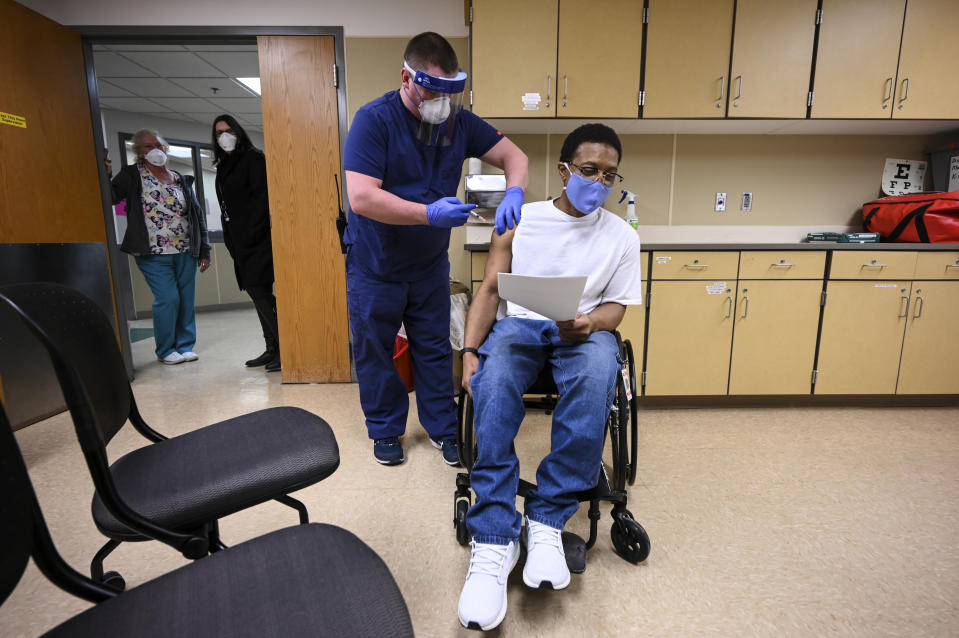 FILE - In this Jan. 4, 2021, file photo, Kelly Markham, a registered nurse supervisor at Faribault Prison, administers the state's first COVID-19 vaccination to a medically vulnerable inmate, Edward Anderson in Faribault, Minn. For 15 months, The Marshall Project and The Associated Press tracked the spread of COVID-19 through prisons nationwide. Twenty states have administered at least one dose of the vaccine to two-thirds of their prison population. (Aaron Lavinsky/Star Tribune via AP, File)