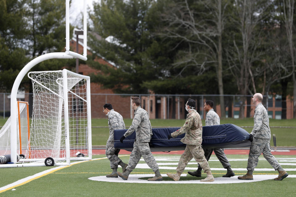 Members of the Connecticut National Guard move sports equipment from a field house to a football and soccer field before unloading supplies for a "surge" hospital that is being constructed to help out during the current coronavirus crisis, Tuesday, March 31, 2020, at Southern Connecticut State University in New Haven. The 250-bed field hospital will facilitate overflow in the event that regional hospitals treating COVID-19 patients reach capacity. (AP Photo/Kathy Willens)