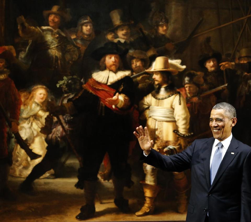 In this March 24, 2014, photo, U.S. President Barack Obama waves in front of Dutch master Rembrandt's The Night Watch painting during a visit to the Rijksmuseum in Amsterdam, Netherlands. From the heart of Europe to the expanse of Saudi Arabia's desert, Obama's weeklong overseas trip amounted to a reassurance tour for stalwart, but sometimes skeptical, American allies. At a time when Obama is grappling with crises and conflict in both Europe and the Middle East, the four-country swing also served as a reminder that even those longtime partners still need some personal attention from the president. (AP Photo/Frank Augstein)