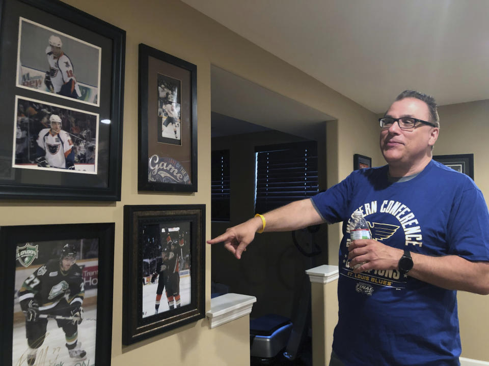 Rob Ferrara points toward photos of his nephew, Patrick Maroon, in his home in St. Louis, Mo., Friday, May 31, 2019. Patrick Maroon had other offers for more money and more years but chose to sign with his hometown St. Louis Blues. He did it for family: for his young son Anthony, his parents and his grandfather, who then died the day before the team left for the playoffs. That day, Maroon said he'd win the Stanley Cup for his late grandfather Ernie and he and the Blues are two wins away from making a lifelong dream come true. (AP Photo/Stephen Whyno)