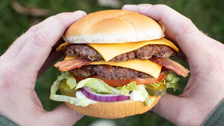 hands holding a double burger