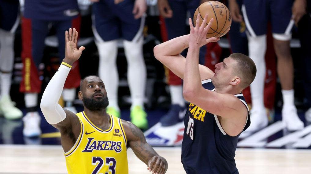 LeBron James (left) tries to block a shot from Nikola Jokic