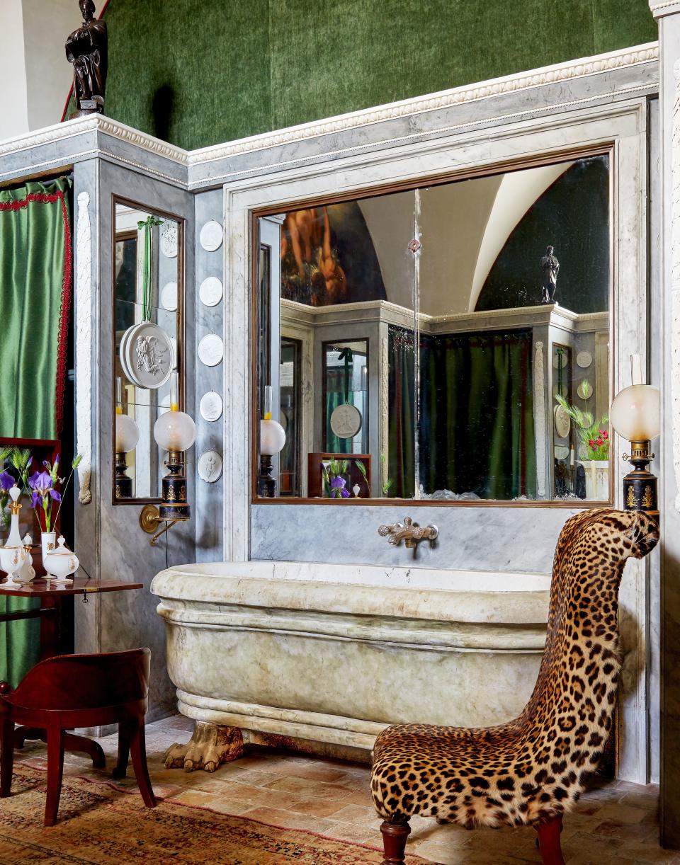 A neoclassical marble tub anchors a bath.