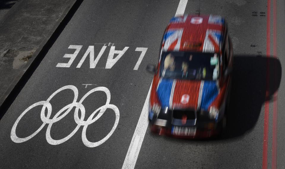 A taxi passes alongside one of the official Olympic Lanes on a street in central London Monday, July 23, 2012, ahead of the 2012 Summer Olympics. (AP Photo/Ben Curtis)