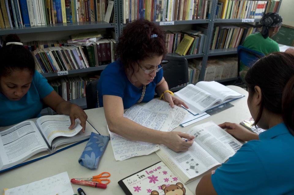 Prisoners study inside the renovated wing of the Najayo women's prison in San Cristobal, May 12, 2014. Ten years after the country opened its first prison designed with a focus on education and clean living conditions and staffed by graduates from a newly created academy for penitentiary studies, the New Model of Prison Management is gaining recognition from other countries in the region trying to reduce prison populations and cut recidivism rates. Picture taken May 12, 2014. REUTERS/Ricardo Rojas (DOMINICAN REPUBLIC - Tags: CRIME LAW POLITICS SOCIETY)