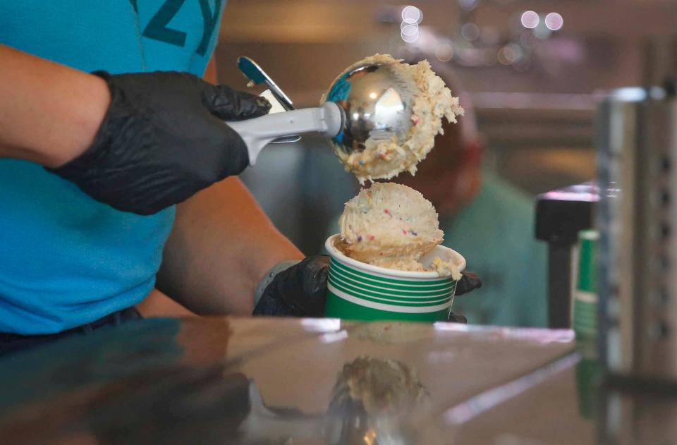 Easton Smith scoops edible cookie dough from the Dough Crazy food truck, a business she co-owns, on Wednesday, June 2, 2021, while on a stop in Carlisle. 